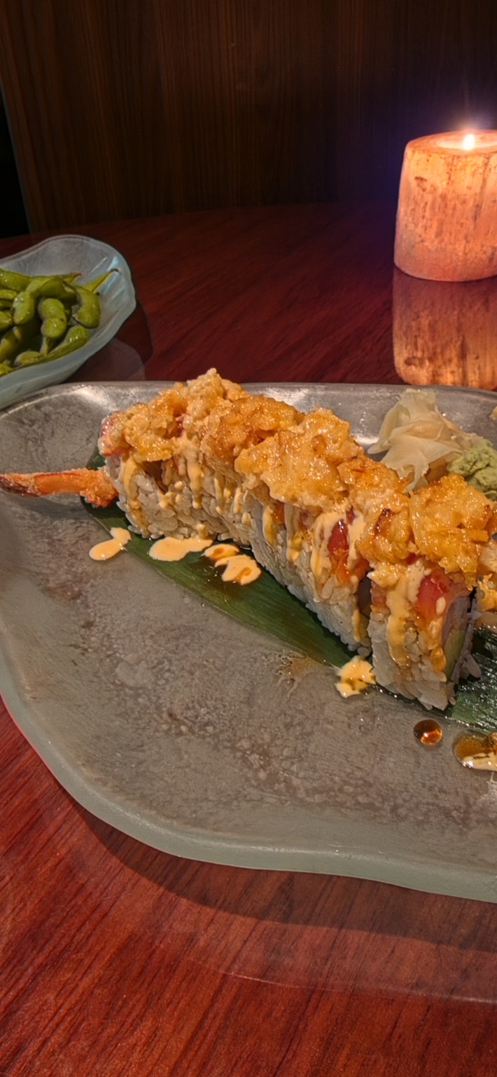 Specialty sushi roll with spicy sauce and crisp topping at Echo Palm Beach