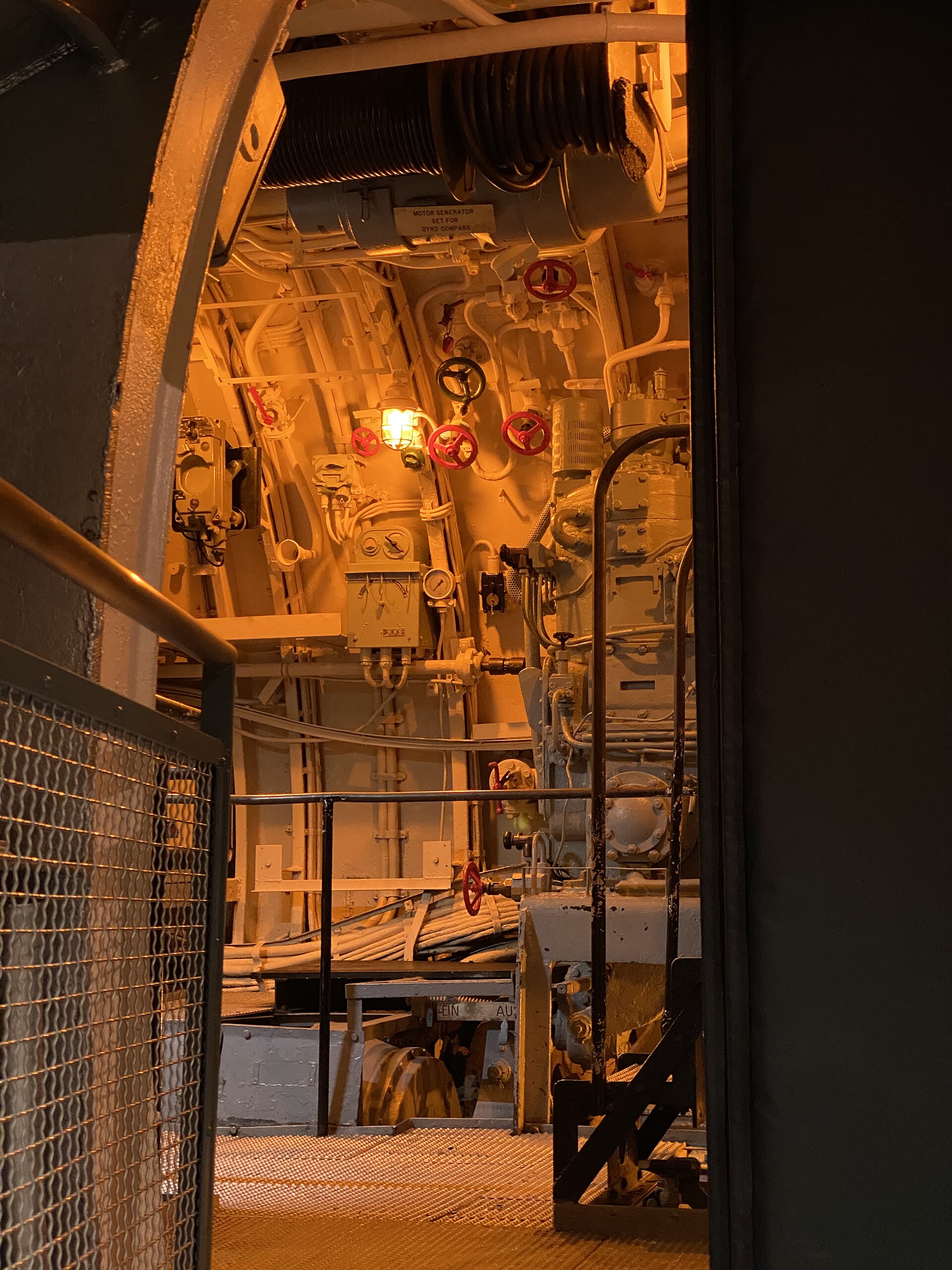 Narrow U-505 submarine machinery space filled with pipes, valves, gauges, and controls